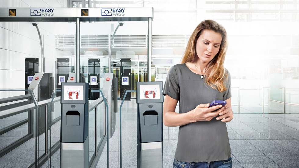 Eine Frau mit Handy neben einem eGate.